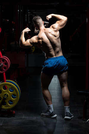 Portrait Of A Young Physically Fit Man Showing His Well Trained Body - Muscular Athletic Bodybuilder Fitness Model Posing After Exercisesの写真素材