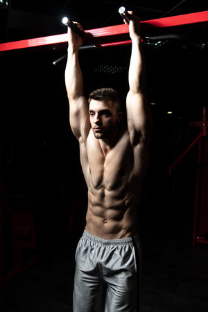 Athlete Performing Hanging Leg Raises Exercise - One Of The Most Effective Ab Exercises