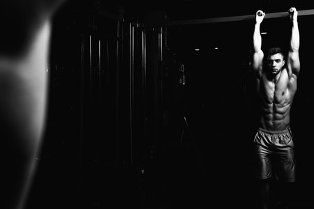 Athlete Performing Hanging Leg Raises Exercise - One Of The Most Effective Ab Exercises