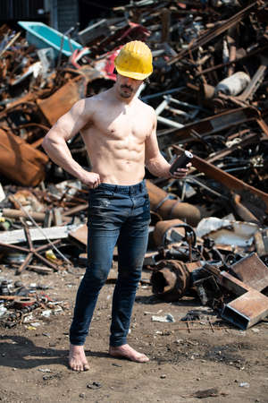 Muscular Man Resting After Exercise and Drinking Bcaa From Can Wearing Yellow Helmetの写真素材