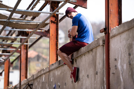 Young Muscular Man Resting  in Warehouse After Exercises - Portrait Of A Physically Fit Young Man