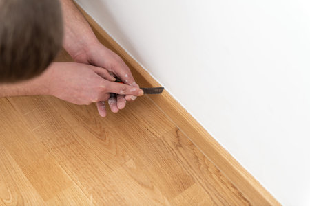 Construction Worker Remove Old Siliicone and Applying New One for Repairing and Installing Parquet...