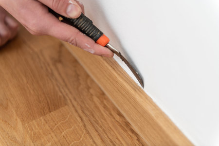 Construction Worker Remove Old Siliicone and Applying New One for Repairing and Installing Parquet...