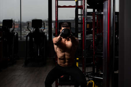 Man Exercising With Kettle Bell And Flexing Muscles - Muscular Athletic Bodybuilder Fitness Model Exercisesの写真素材