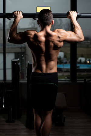 Handsome Bodybuilder Doing Heavy Weight Exercise For Back On Machineの写真素材