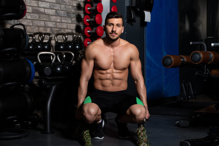 Battling Ropes Young Man At Gym Workout Exercise