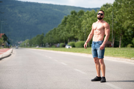 Handsome Beard Man Standing Strong and Posing at Outdoors - Background Nature of Leavesの写真素材