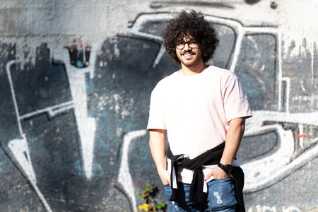 Portrait of Stylish Arab Beard Afro Man on a Graffiti Wall Outside
