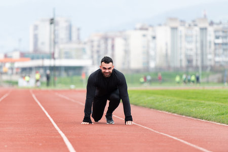 Fit and Confident Man in Starting Position Ready for Running