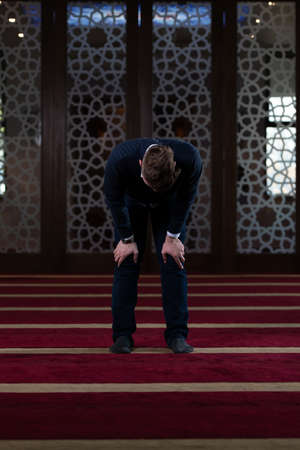 Attractive Man Making Traditional Prayer to God Allah in the Mosqueの写真素材