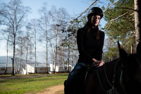 Portrait of Confident Female Jockey With Horse Standing on Fieldの写真素材