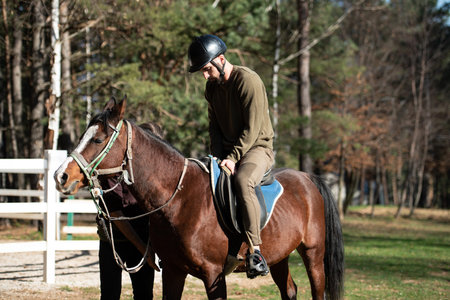 Young Man Jockey Riding Brown Horse Strolling Across Field