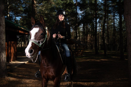 Portrait of Confident Female Jockey With Horse Standing on Field
