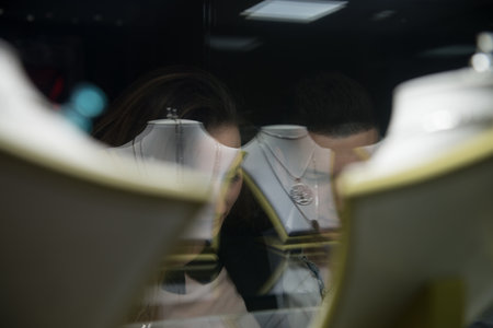 Young Couple Watching Jewel Outside a Jewellery they Stand Near the Shop Window Indoorの写真素材