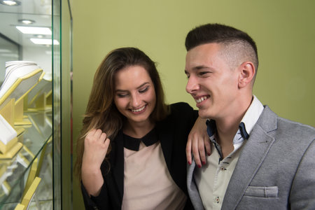 Young Couple Watching Jewel Inside a Jewellery they Stand Near the Shop Window Indoor