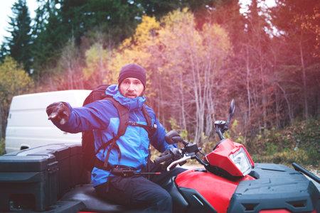 Emergency Man in Protective Uniform on Quad in Forest Searching Missing Person