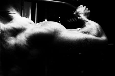 Handsome Athlete Doing Heavy Weight Exercise For Back On Machineの写真素材