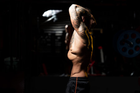 Handsome Man Standing Strong In The Gym And Flexing Vacuum Abdominal Muscles - Muscular Athletic...