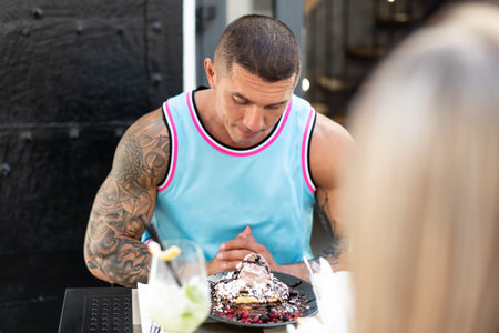 Portrait of Young Couple Eating Pancakes Outdoors Restaurant and Drinking Cocktail