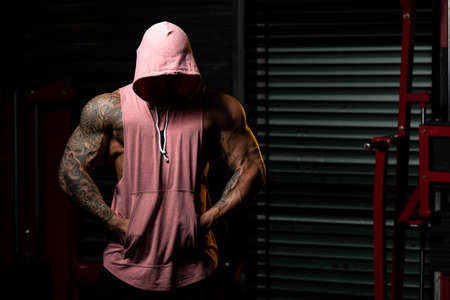 Portrait Of A Physically Fit Man In Hoodie - In Modern Fitness Center - Showing Offの写真素材