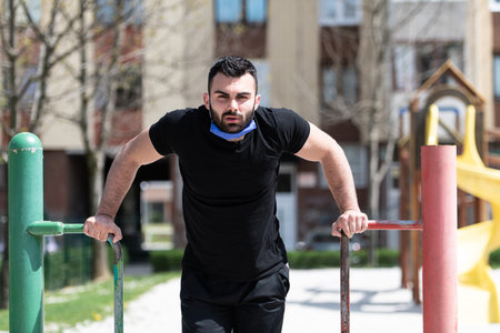 Young Athlete Working Out Triceps In An Outdoor Gym - Doing Street Workout Exercises