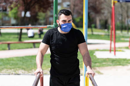 Young Athlete Working Out Triceps In An Outdoor Gym - Doing Street Workout Exercisesの写真素材
