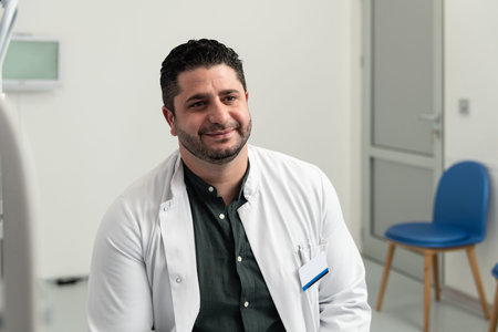 Portrait of Handsome Eye Doctor Sitting With Ophthalmologic Device in the Cabinet