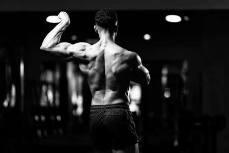 Portrait Of A Young Physically Fit Man Showing His Well Trained Body - Muscular Athletic Bodybuilder Fitness Model Posing After Exercisesの写真素材