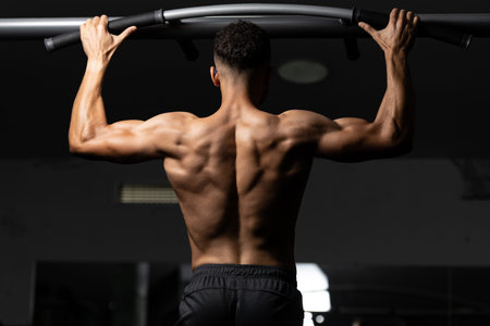 Handsome Athlete Doing Heavy Weight Exercise For Back On Machine
