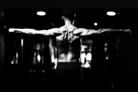 Handsome Young Man Standing Strong In The Gym And Flexing Muscles - Muscular Athletic Bodybuilder...