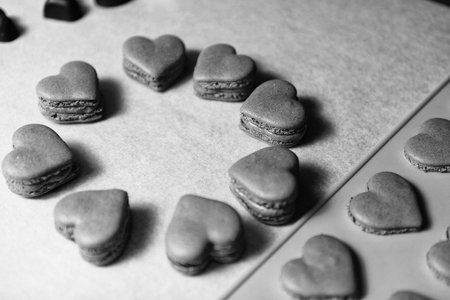 Black and White Heart Macarons Dessert on Baking Parchment Paperの写真素材
