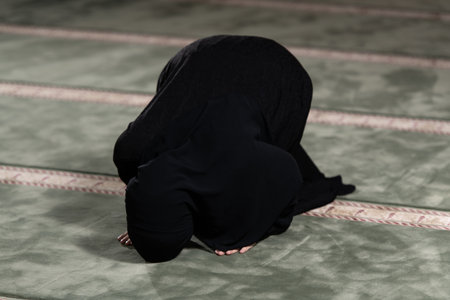 Muslim Woman Who is Wearing the Islamic Long Hijab Khimar Was Praying and Doing Dua at the Mosque for Islamic Religious Ceremonyの写真素材