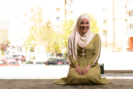Beautiful Muslim Woman in Hijab Dress Sitting in Mosque and Prayingの写真素材