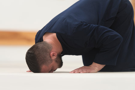 Young Muslim Man Making Traditional Prayer To God While Wearing A Traditional Cap Dishdashaの写真素材