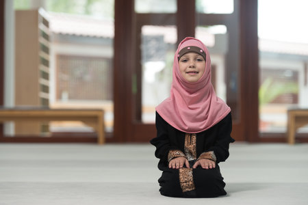 Young Muslim Girl Making Traditional Prayer To God While Wearing A Traditional Headscarfの写真素材