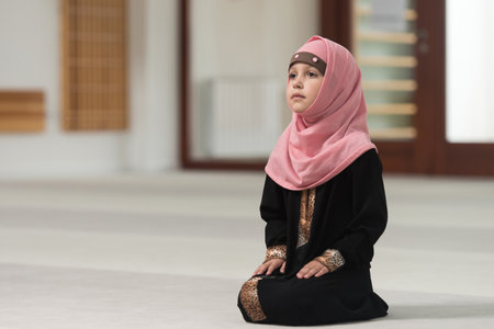 Young Muslim Girl Making Traditional Prayer To God While Wearing A Traditional Headscarfの写真素材