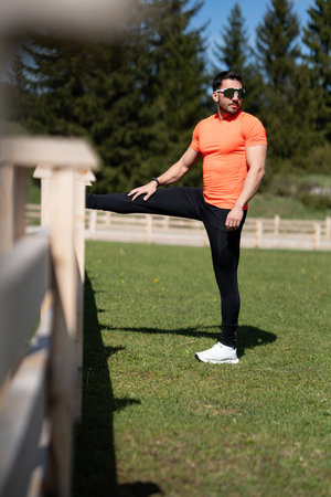 Man Stretching To Warm Up On A Sunny Day In A Scenic Outdoor Location