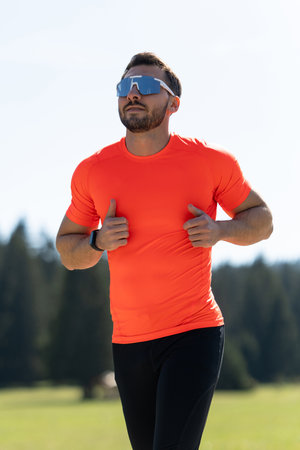 Athlete Jogging On A Dedicated Running Path With Stunning Natural Views Of Grass, Forests, And Distant Mountainsの写真素材