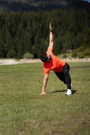 Man Stretching His Full Body Outdoors On A Beautiful Sunny Day In Natureの写真素材