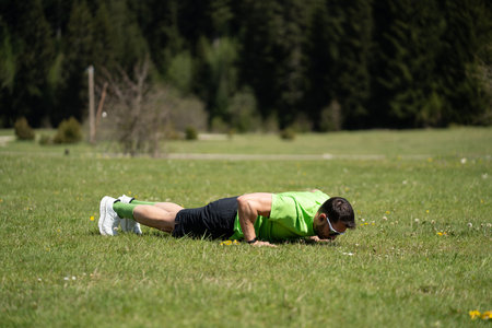 Athletic Male Exercising Outdoors With Dynamic Push-Up Techniqueの写真素材