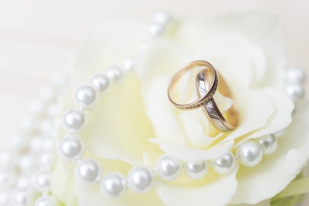 wedding rings on a flower with bright pearlsの写真素材