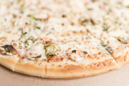 Pizza with mushrooms, ham and pickled cucumbers close-upの写真素材