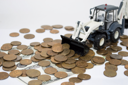 A tractor raking coins. financial business conceptの写真素材