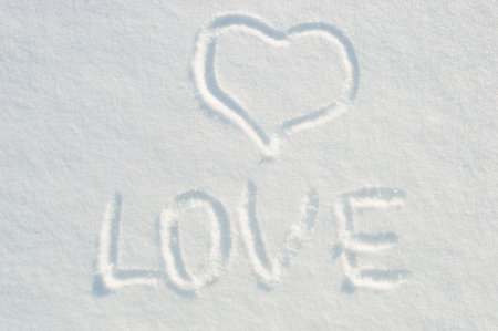 Heart shape love symbol for valentine day drawn on white snowの写真素材