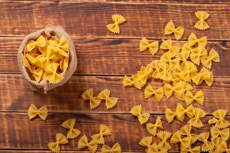Pasta Dry in sackcloth bag on the old table wood background closeup.