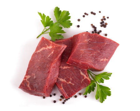 raw meat beef with green parsley and black pepper isolated on white background