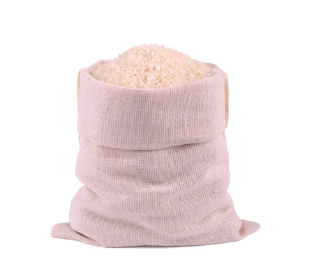 White rice in burlap sack bag isolated on white background.の写真素材