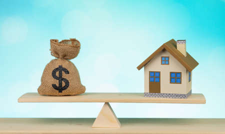 Home and money bag Us dollar sign put on the scales with balance saving for a real estate concept loan for plan business investment in the futureの写真素材