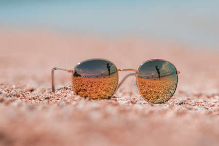 Sunglasses in the sand with pastel color styles. Summer concept stock images.の写真素材