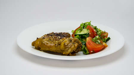 Grilled chicken fillet with salad on a white plate on a white backgroundの写真素材